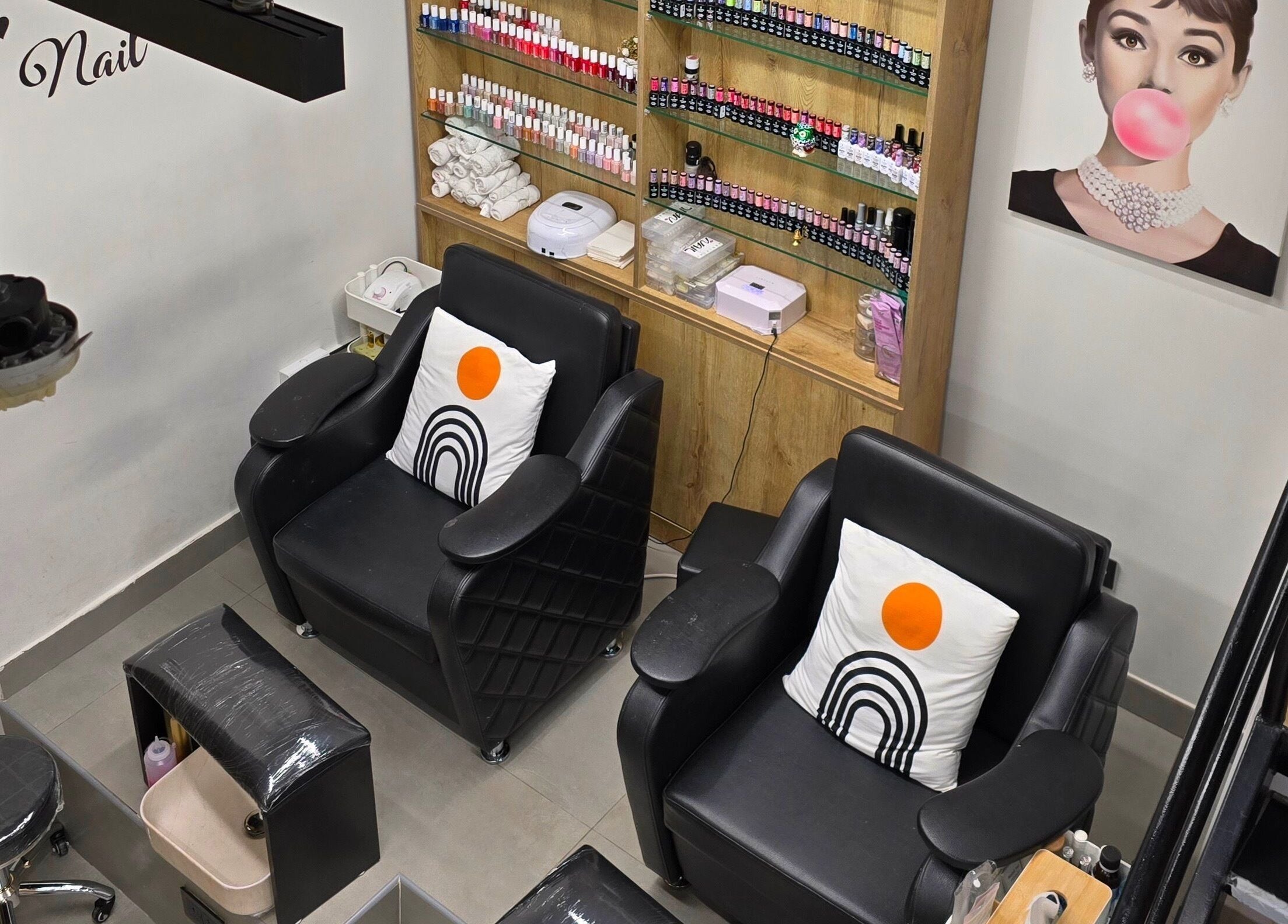 TREVI SALON nail care room in Dubai, Dubai, AE with plush chairs and nail polish display.