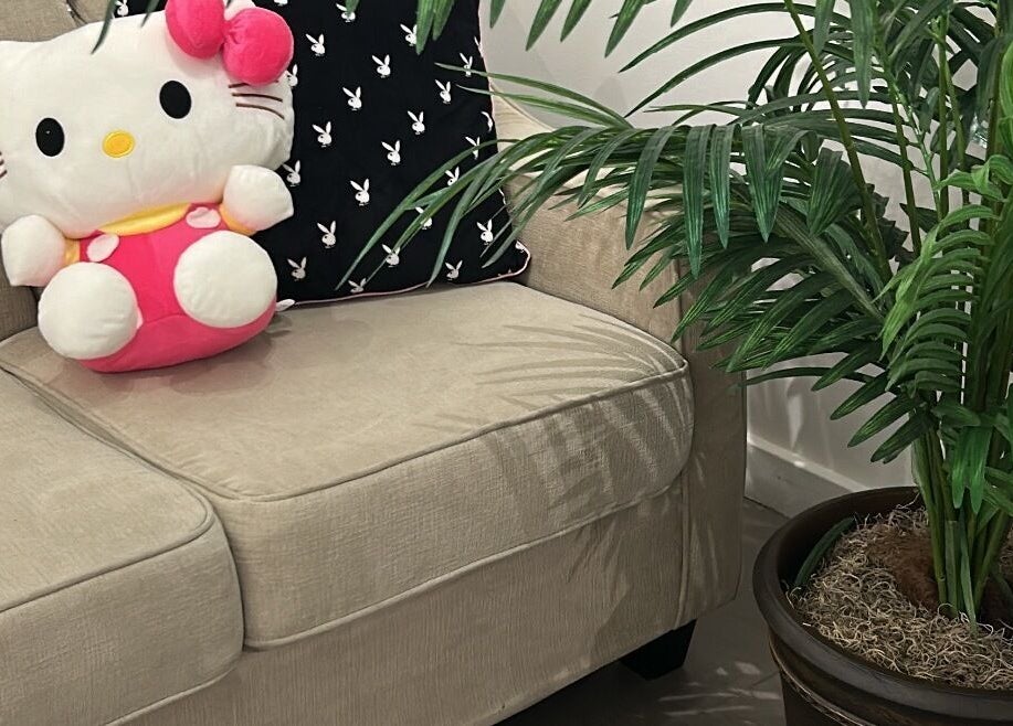 Inviting couch with plush toy and greenery at Lashes by Rina in Calgary, Alberta, CA.