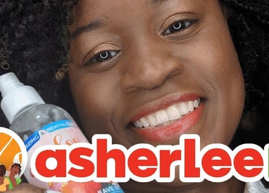 Smiling customer holding a natural hair product at Asherlee Naturals, Kingston, St. Andrew Parish, JM.