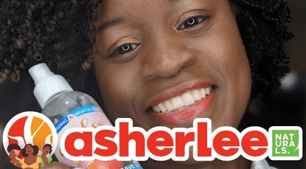 Smiling customer holding a natural hair product at Asherlee Naturals, Kingston, St. Andrew Parish, JM.