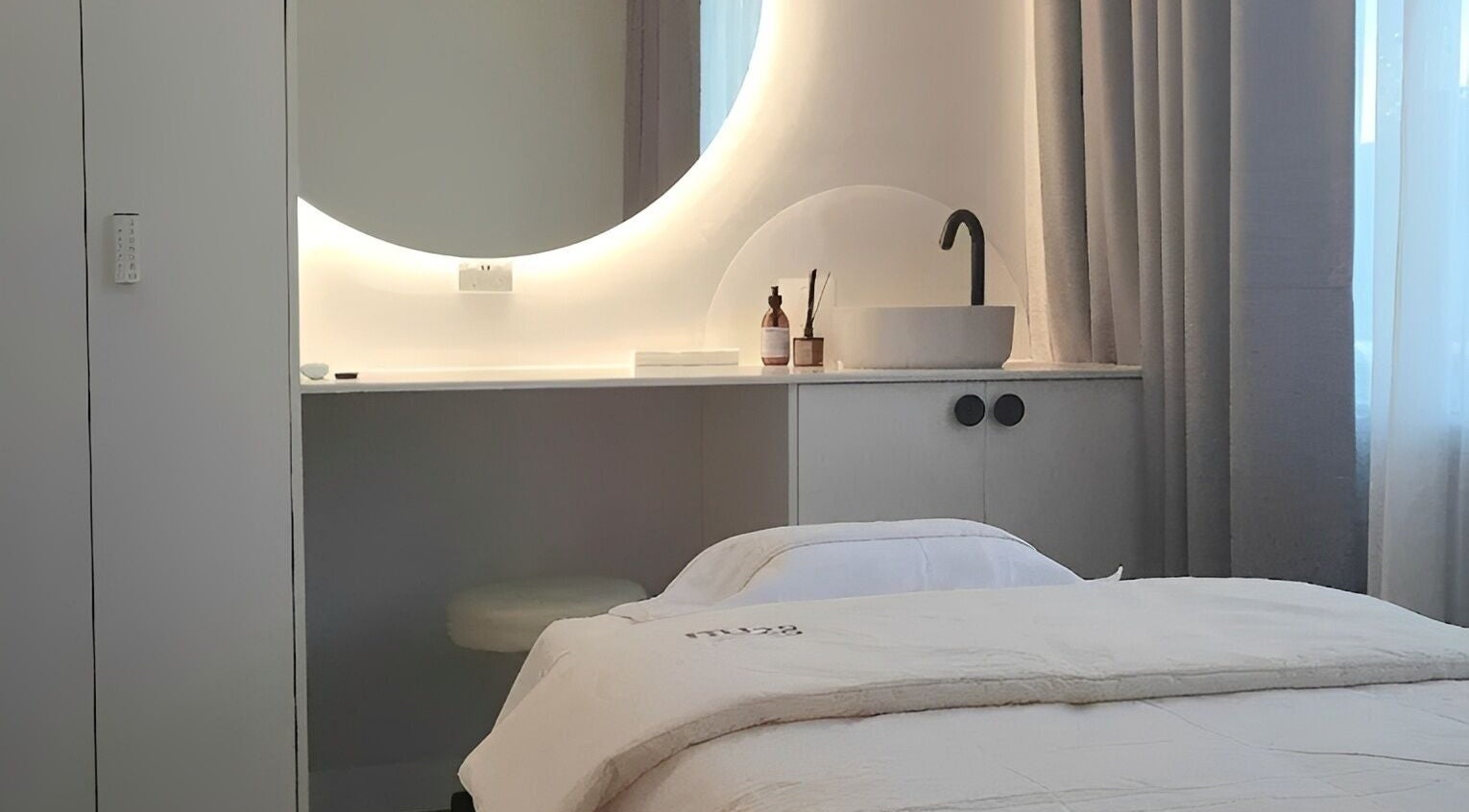 Modern treatment room with round mirror at NU28 Medical Aesthetics, Melbourne, Victoria, AU.