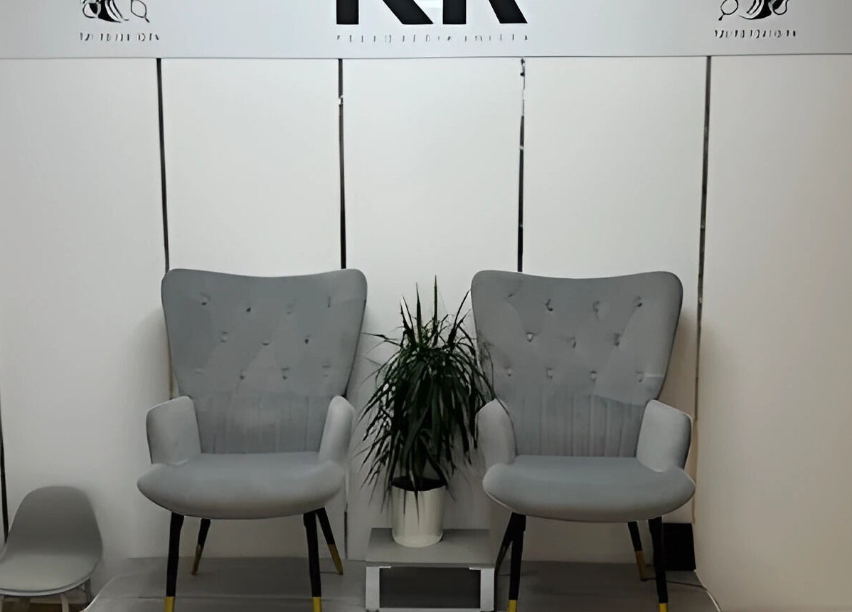 Zona de espera en KR - Katalina Rios Peluqueria, Barcelona, Catalunya, ES, con cómodos sillones grises.