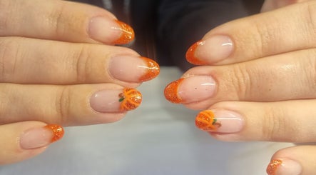 Stylish pumpkin-themed manicure at Krisu, Wolverhampton, England, GB. Features orange and glitter accents.