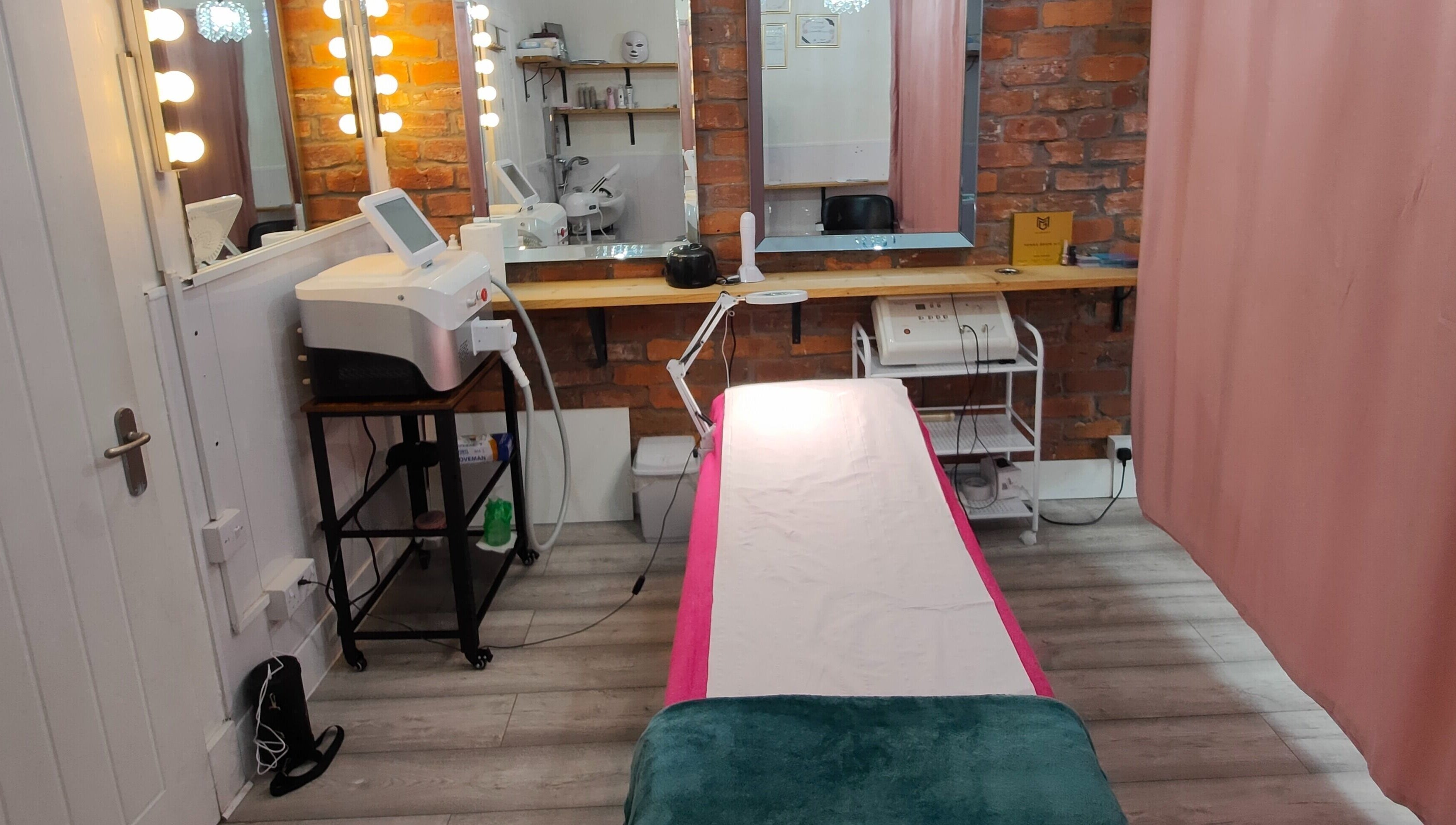 Modern therapy room at Beren Beauty Salon, Edinburgh, Scotland, GB with treatment bed and mirrors.