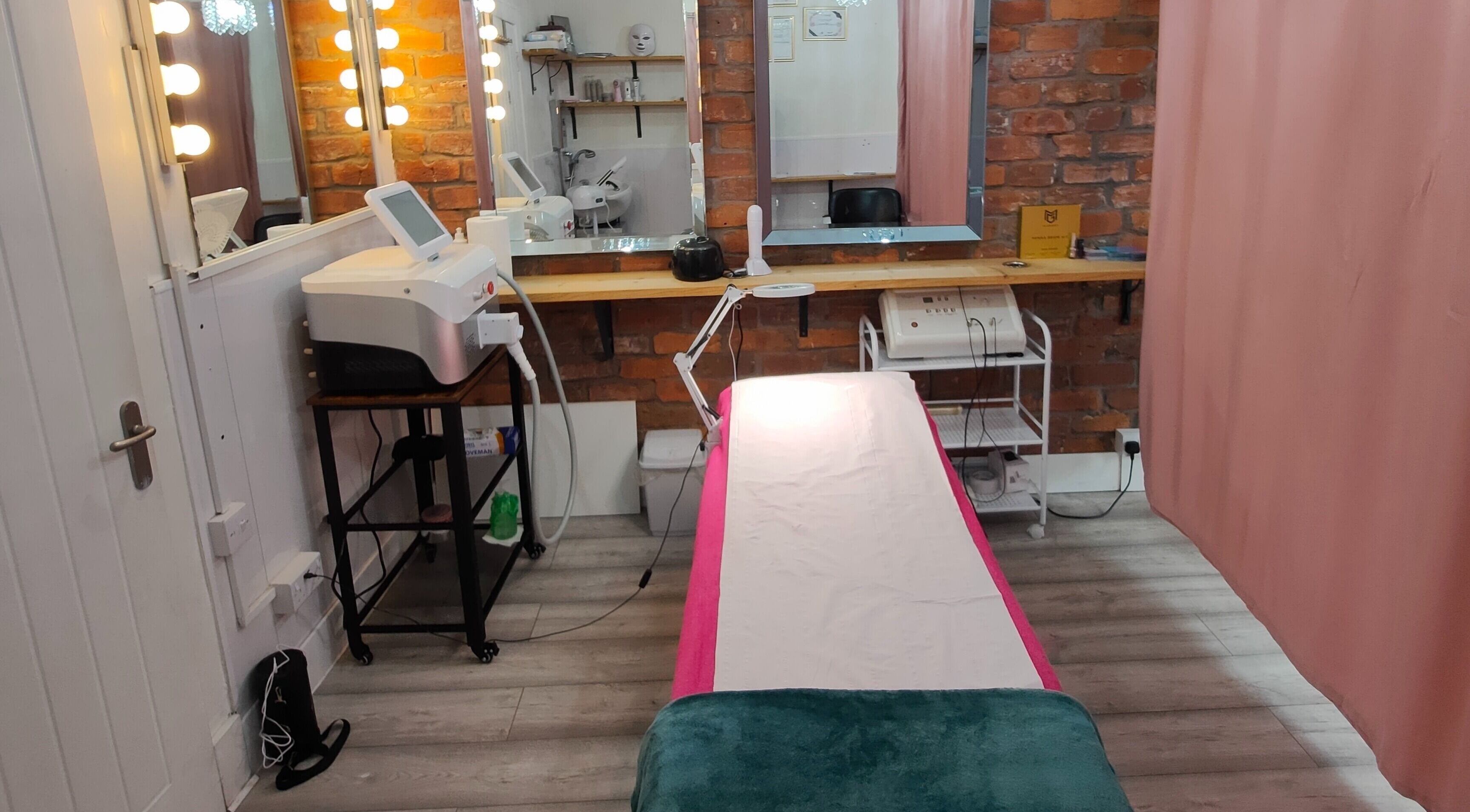 Modern therapy room at Beren Beauty Salon, Edinburgh, Scotland, GB with treatment bed and mirrors.