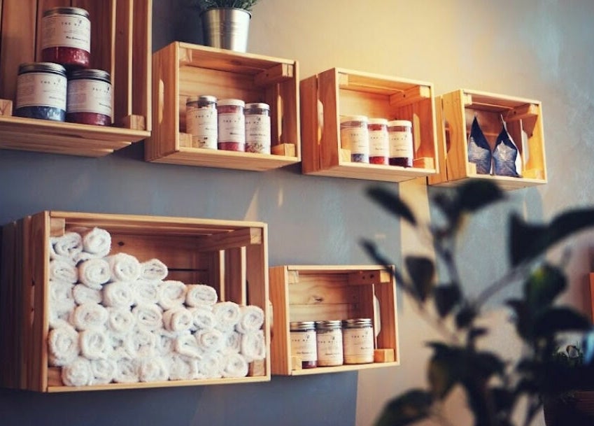 Wooden shelves at The Nail Bar Murray Bridge, Murray Bridge, South Australia, AU with products and towels.