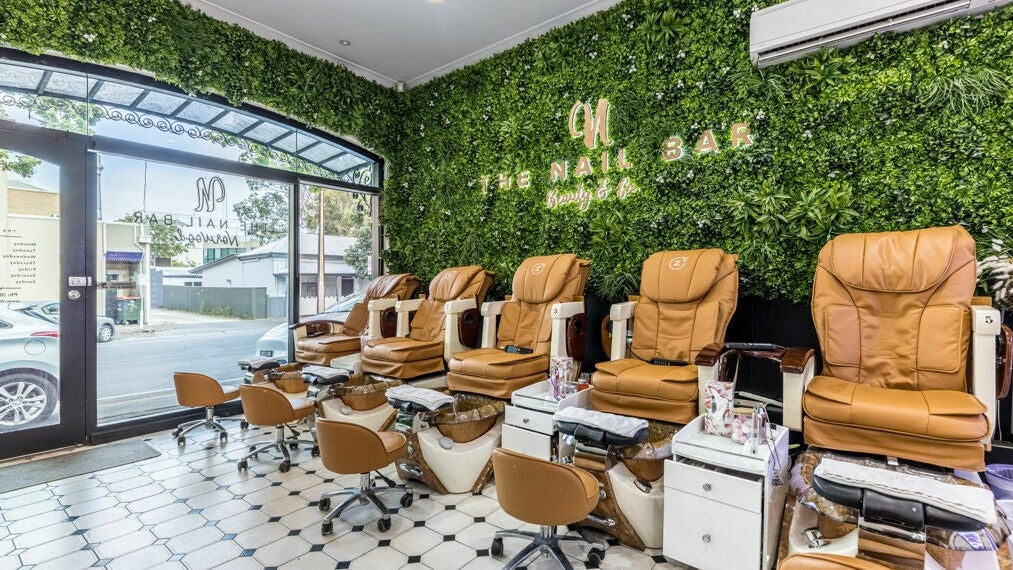 Relaxing nail salon chairs at The Nail Bar Norwood, Norwood, South Australia, AU with lush greenery wall.