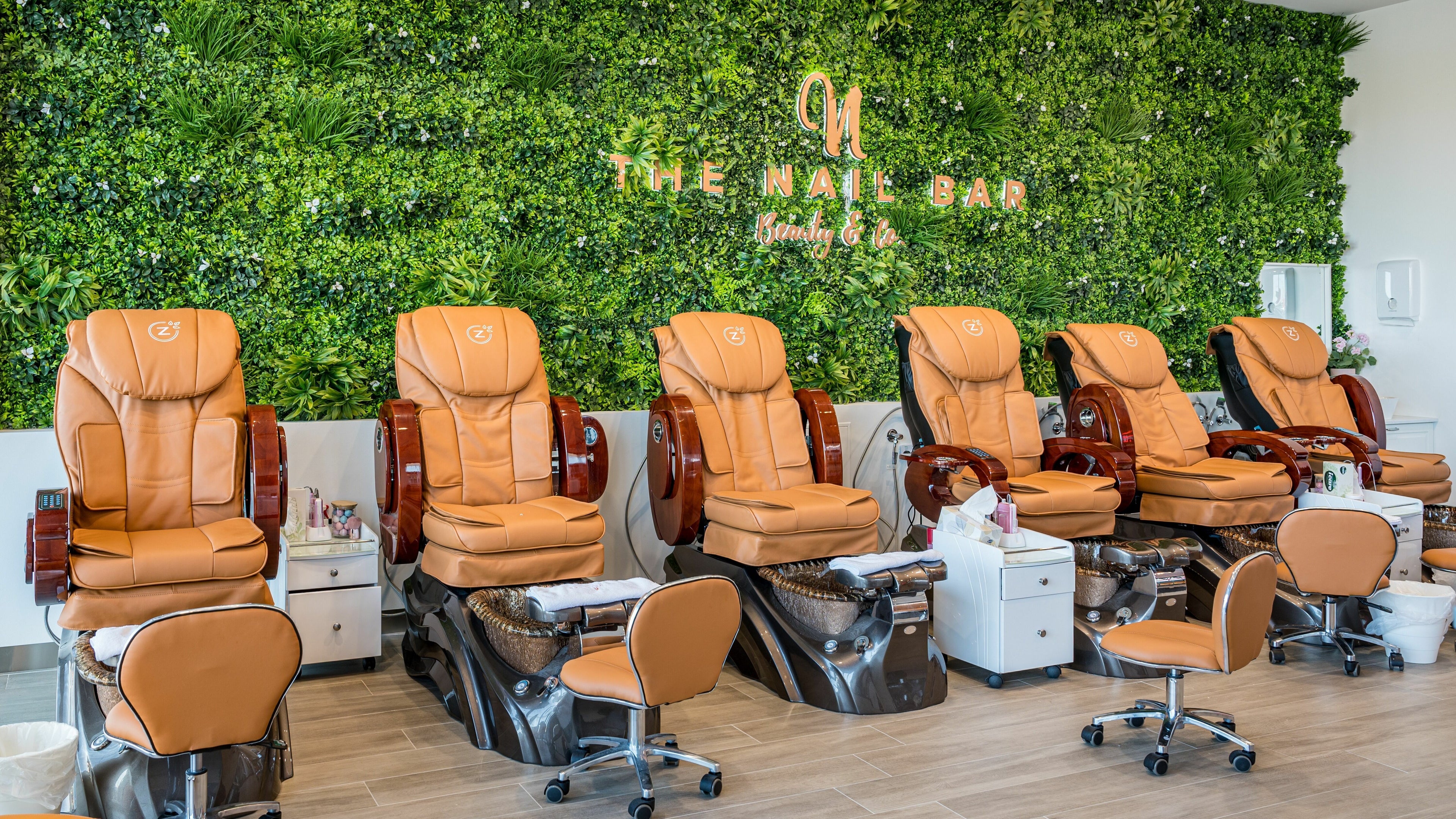 Luxury pedicure chairs at The Nail Bar Hendon, Hendon, South Australia, AU, set against a lush green wall.