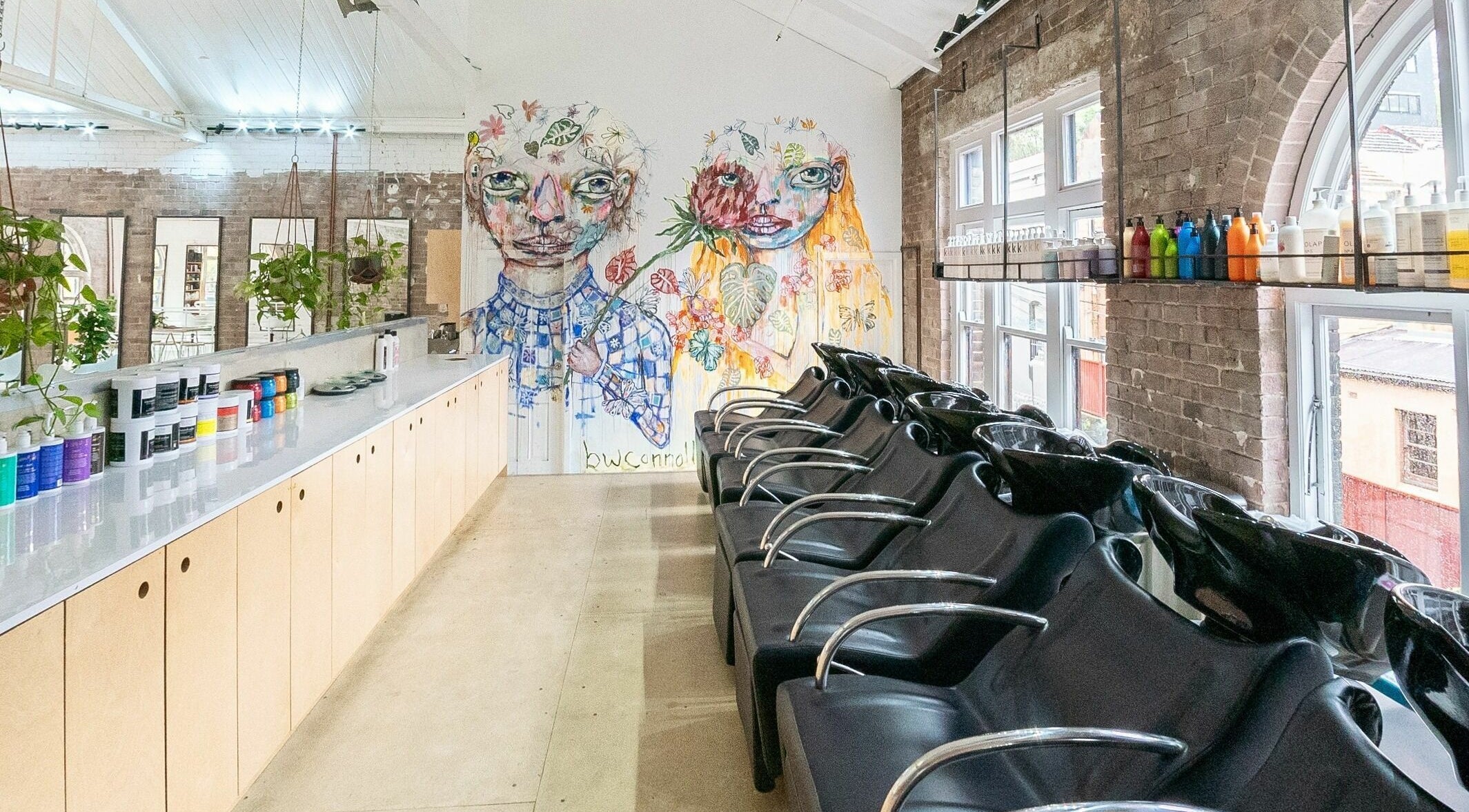 Stylish salon interior at E+Co - Kippax Street in Surry Hills, New South Wales, AU with vibrant mural art.