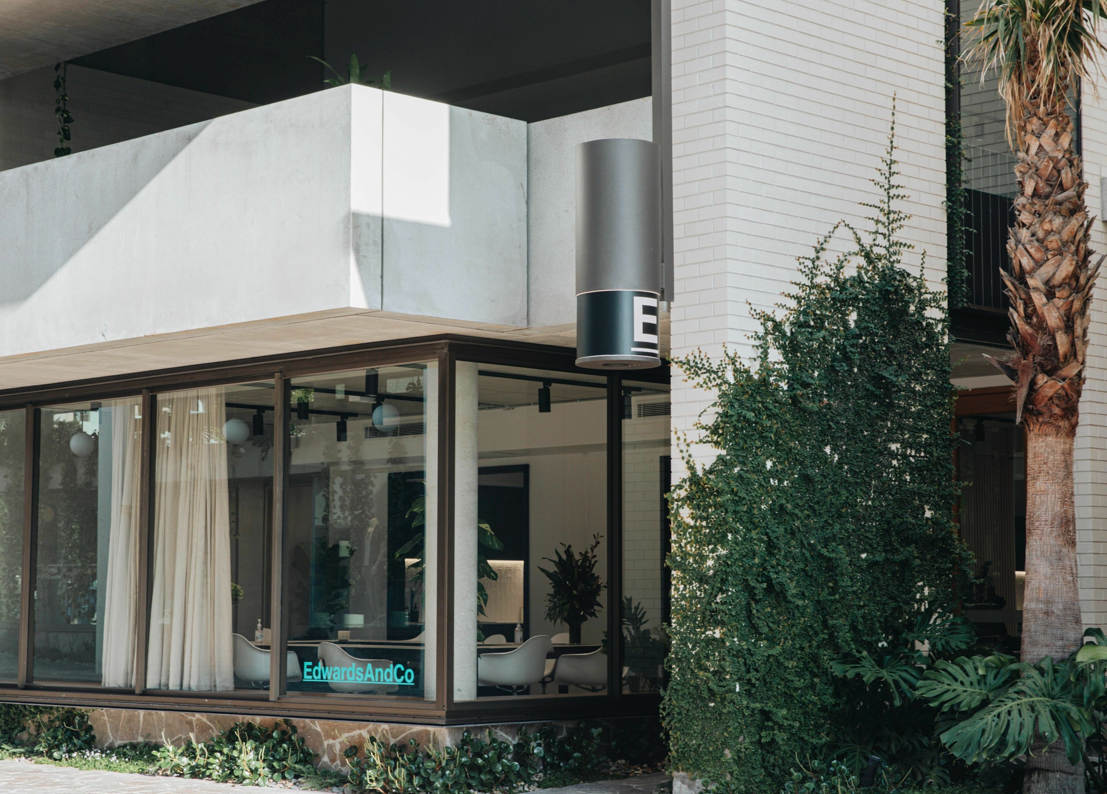 Exterior view of E+Co - Fortitude Valley, showcasing greenery and modern architecture in Fortitude Valley, Queensland, AU.