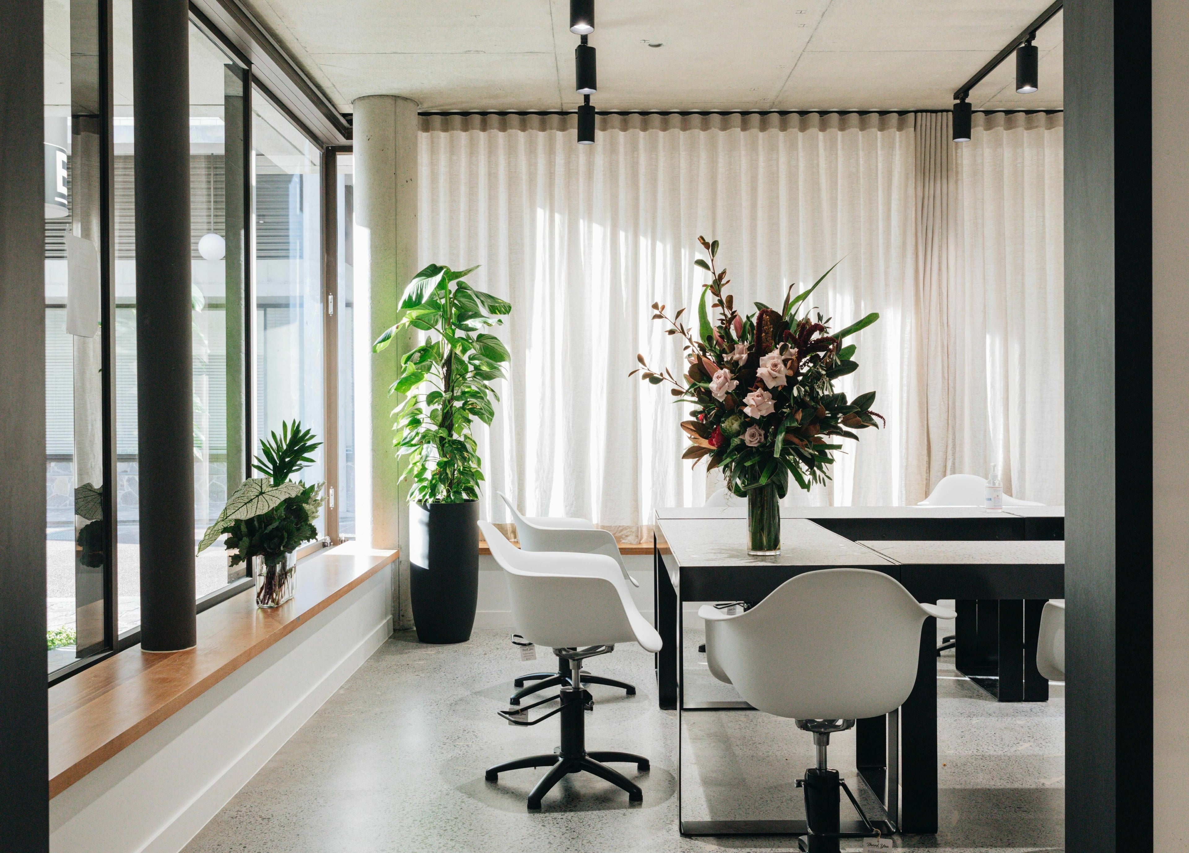 Modern interior of E+Co - Fortitude Valley, featuring sleek seating and lush plants, in Queensland, AU.