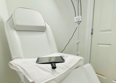 Comfortable treatment chair at Emma Fox Aesthetics in Heybridge, England, GB, with soft towel and tablet.