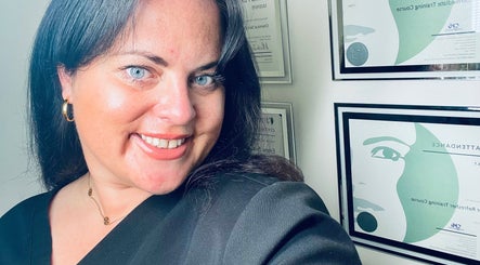 Owner at Emma Fox Aesthetics in Heybridge, England, GB, smiling inside a certification-adorned space.