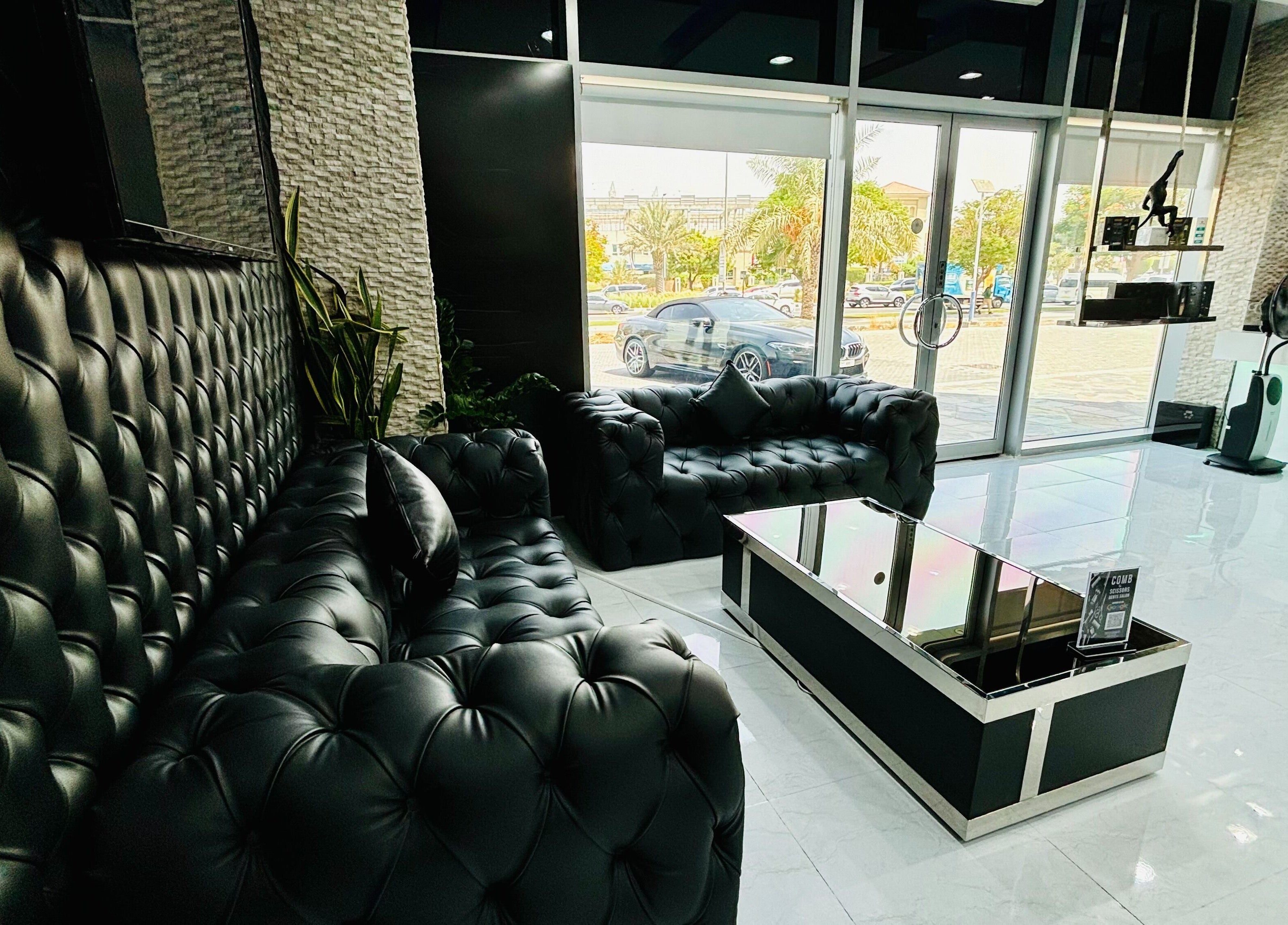 Stylish lounge at Comb and Scissors Gents Salon, Dubai, AE with plush seating and modern decor.