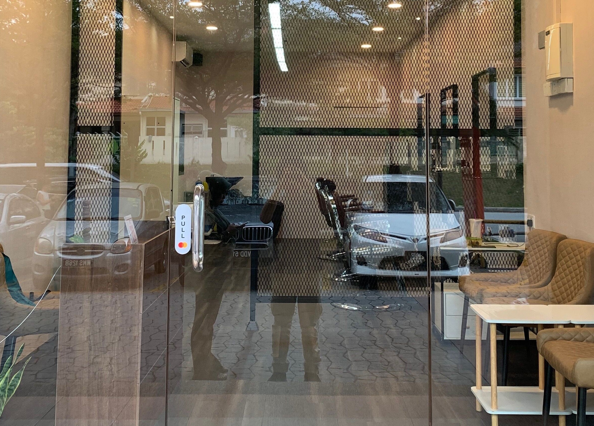 Entrance of The Barbersmith Damansara in Petaling Jaya, Selangor, MY with sleek chairs and modern decor.