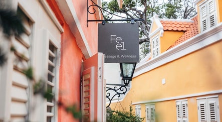 Feel Massage and Wellness ‘Kura Hulanda’ sign on colorful street in Willemstad, Curaçao, CW.