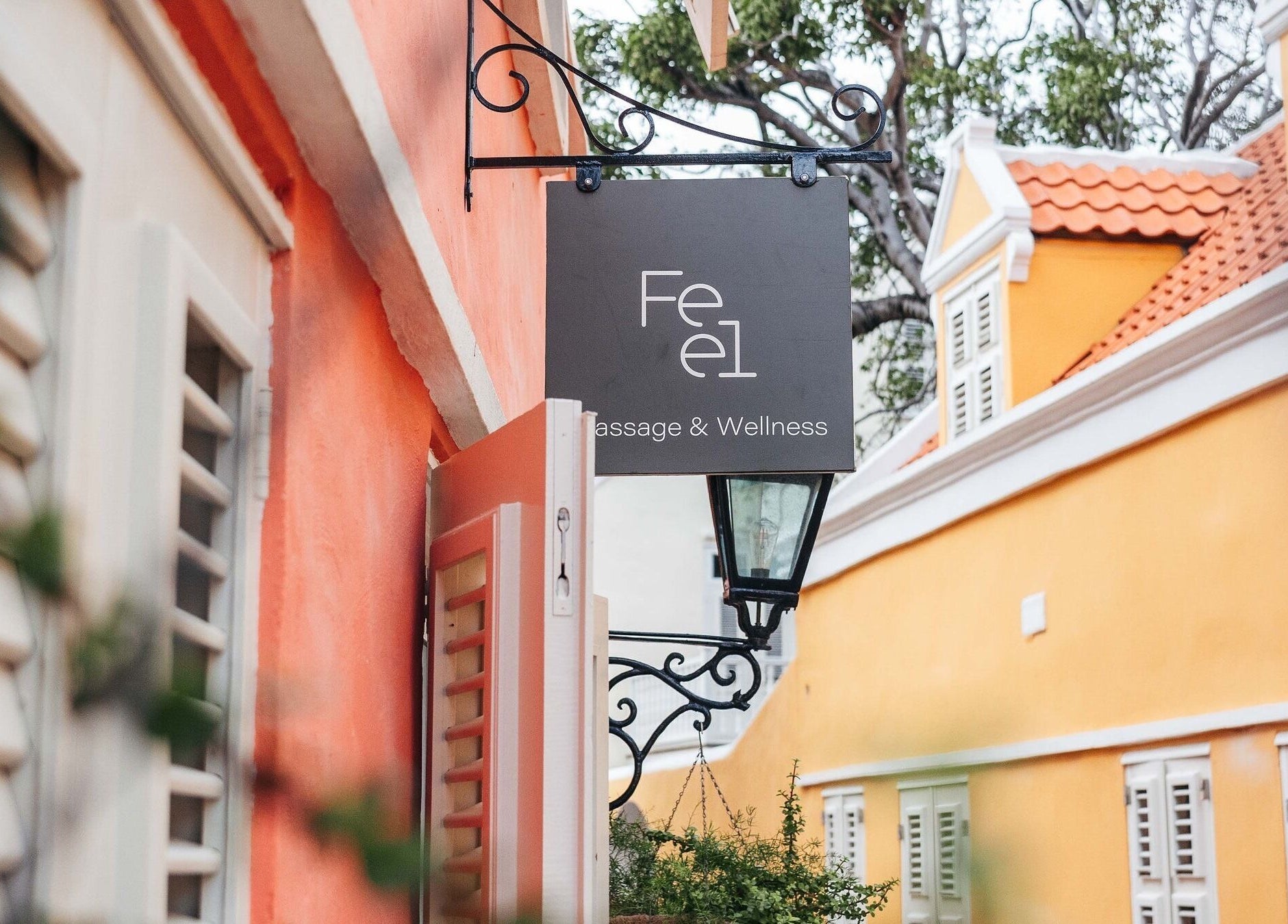 Feel Massage and Wellness ‘Kura Hulanda’ sign in vibrant Willemstad, Curaçao, CW street view.