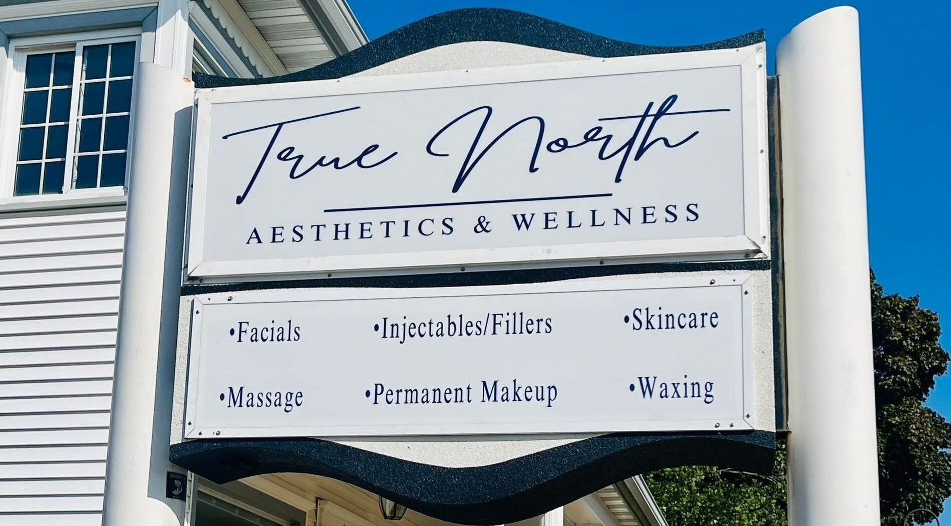 Signage for True North Aesthetics & Wellness LLC, Rhinelander, Wisconsin, US showcasing services like facials and massage.