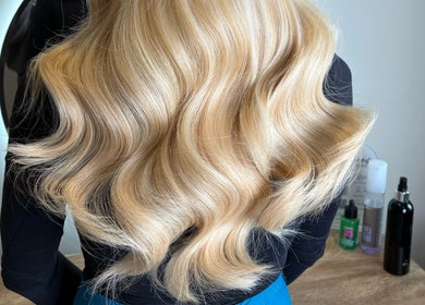 Blonde wavy hair styled at Extensions by Beth, Harrogate, England, GB, showcasing luminous curls.