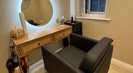 Cozy salon station at Extensions by Beth, Harrogate, England, GB with elegant black chair and wooden vanity.