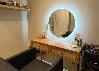 Warm-lit styling station at Extensions by Beth, Harrogate, England, GB with products and a round mirror.
