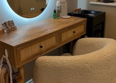 Elegant styling station at Extensions by Beth, Harrogate, England, GB with plush chair and wooden desk.