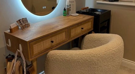 Elegant styling station at Extensions by Beth, Harrogate, England, GB with plush chair and wooden desk.
