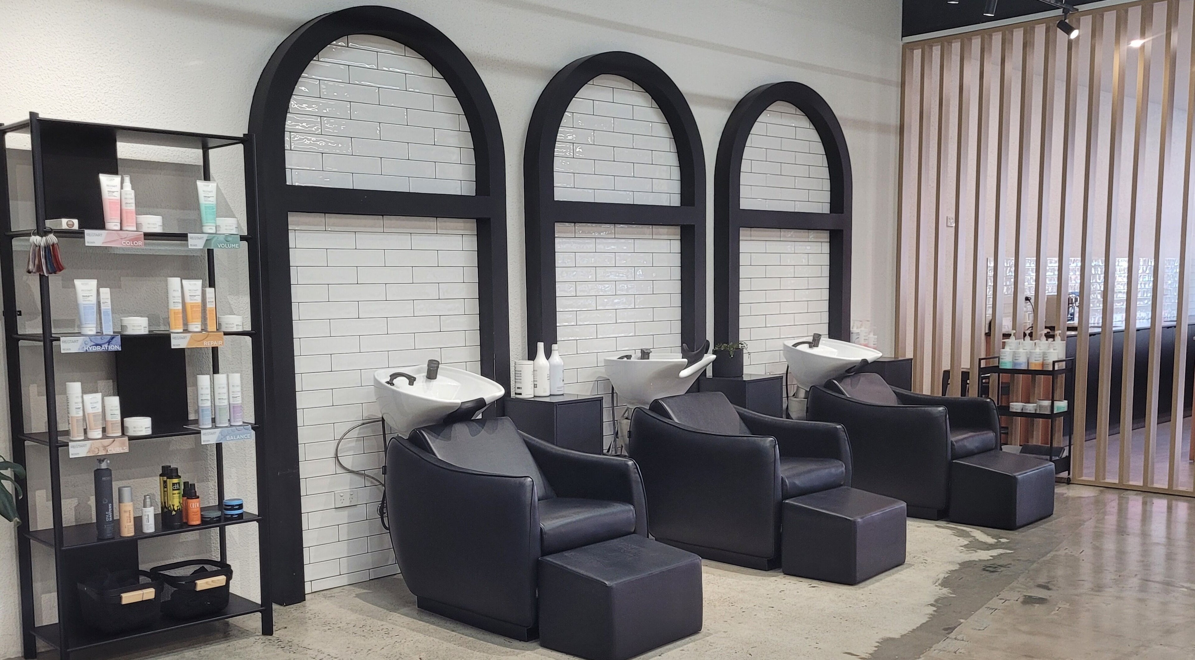 Luxurious wash stations at Kristy Campbell at Style Bar, Werribee, Victoria, AU with sleek black chairs and products.