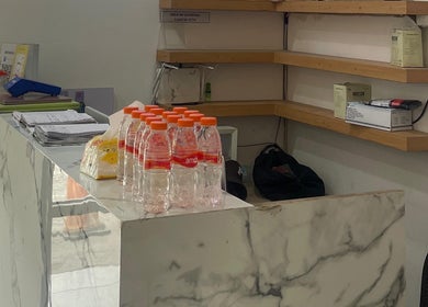 Marble reception desk at MORI SALON, Jawa Timur, ID with water bottles and shelves in the background.