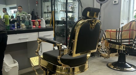 Elegant barber chair at Mildred Barber, Stamford, Connecticut, US, showcasing luxurious gold and black design.