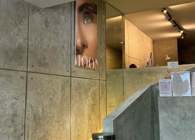 Lobby of Moonlash Studio Tukad Barito in Bali, Bali, ID, showcasing chic gray walls and beauty posters.