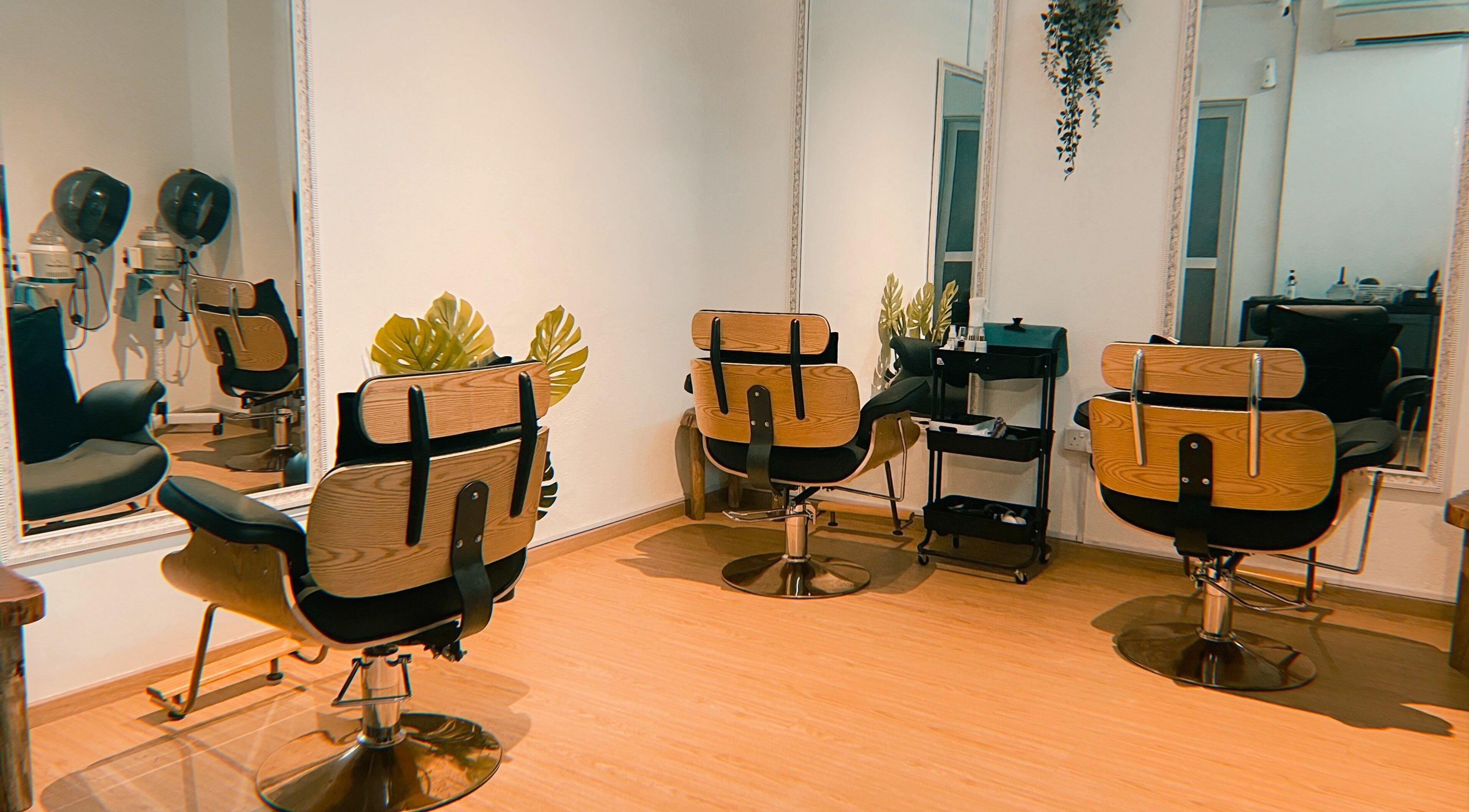 Chic beauty salon interior at Charmtress.Sg in Singapore, Singapore, SG with stylish wooden chairs and mirrors.