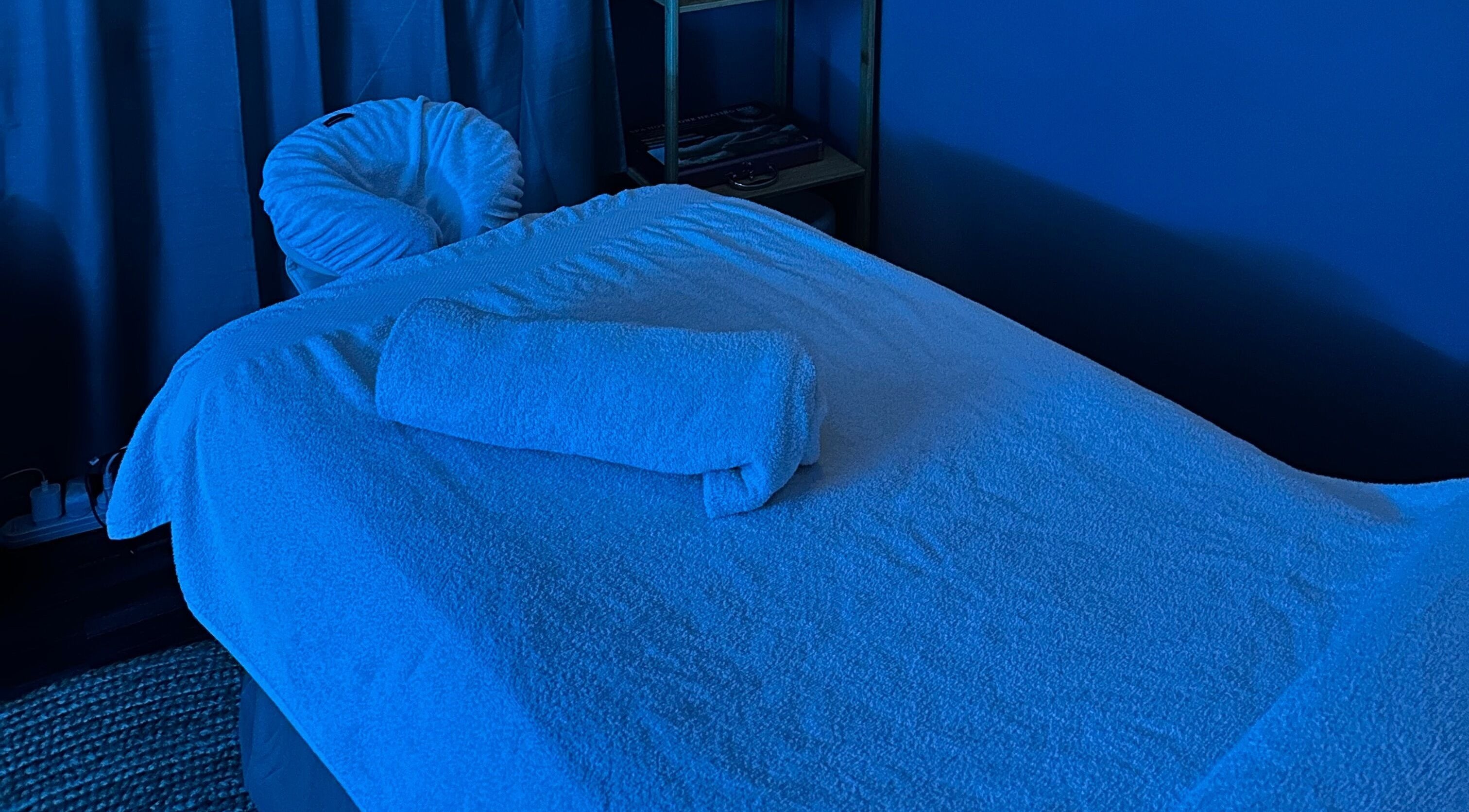 Luxurious massage bed in a tranquil blue room at Thyme & Calm, Kangaroo Point, Queensland, AU.