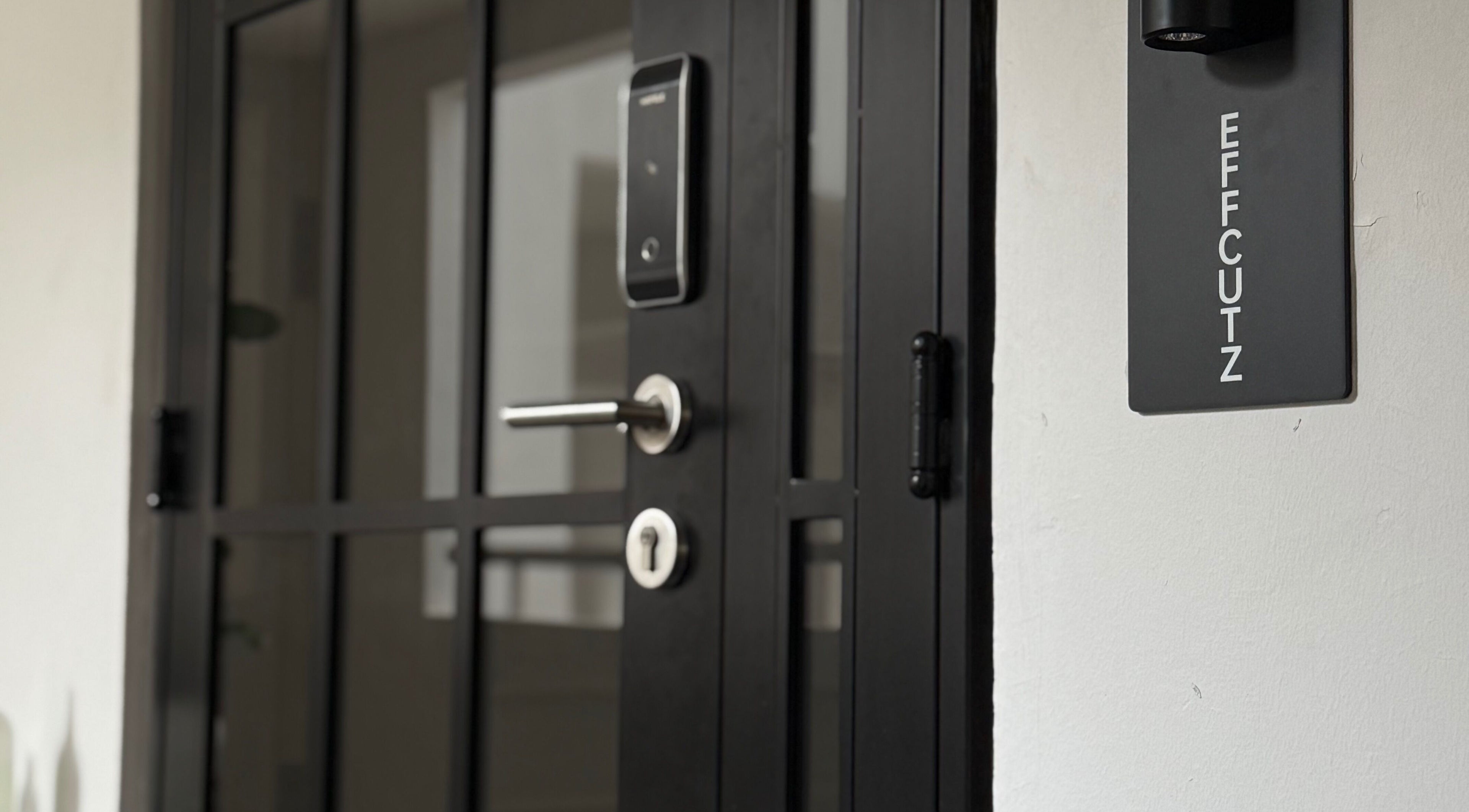 Effcutz entrance showcasing sleek black door with logo in Singapore, Singapore, SG.