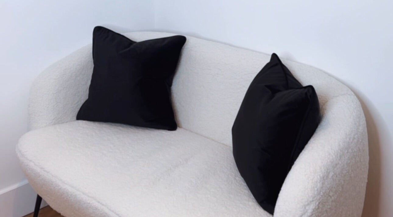 A stylish white sofa with black cushions at The Laser Bar Essex in Loughton, England, GB.