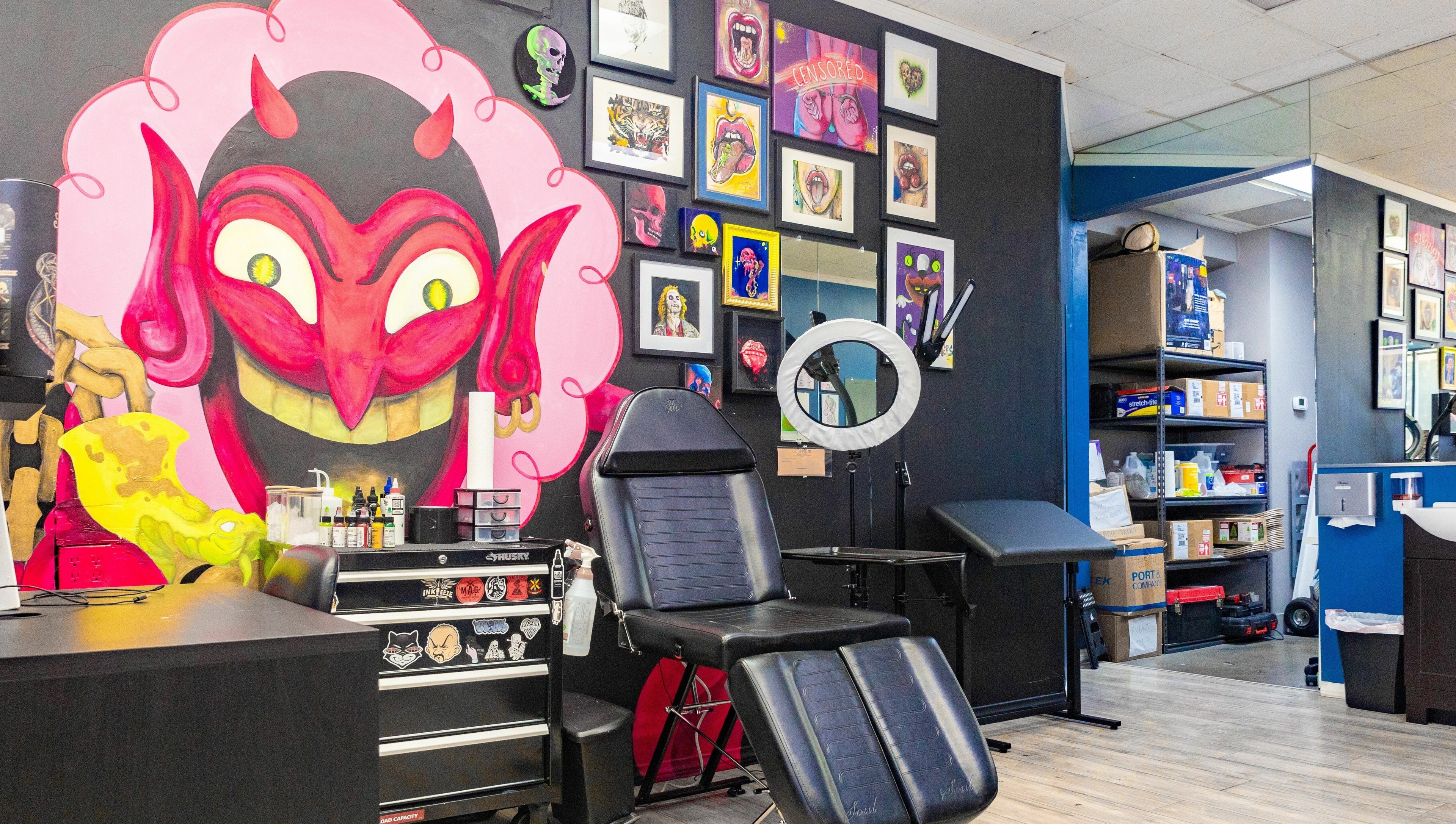 Vibrant tattoo studio wall art and chair at Mr. Inkwells, Los Alamitos, California, US.
