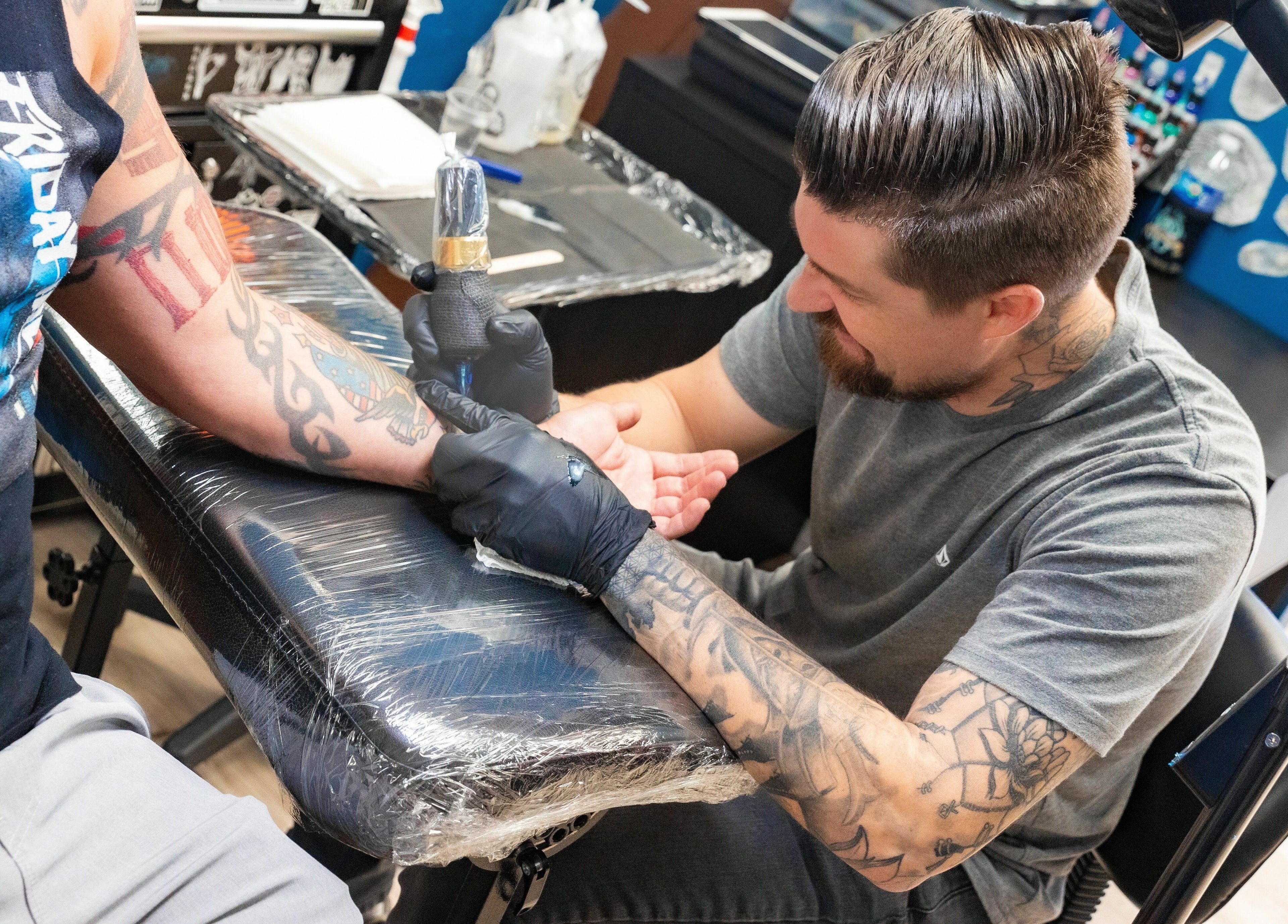 Artist creating a tattoo at Mr. Inkwells, Los Alamitos, California, US. Experience the best in tattoo artistry.