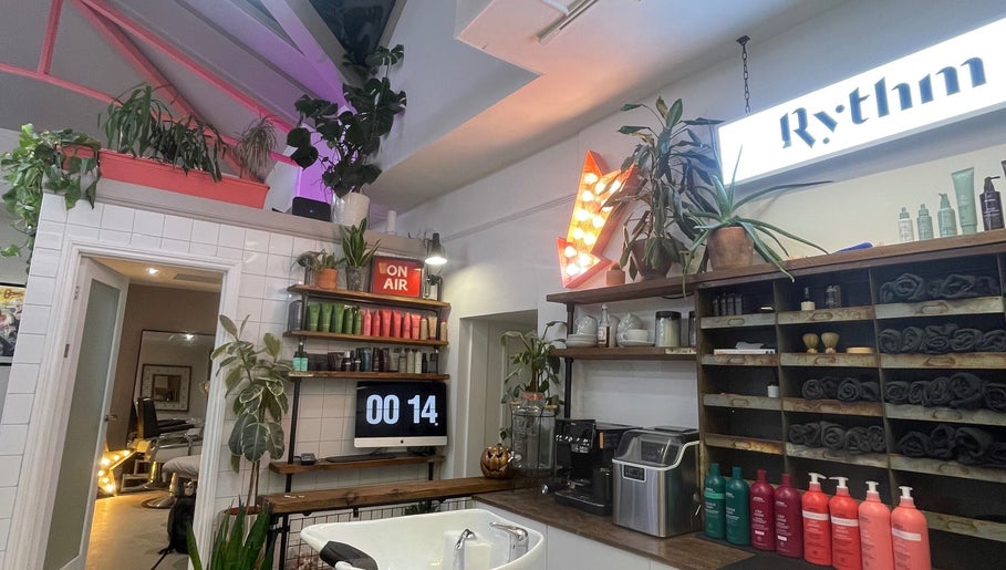 Cozy interior of Rythm Barbering in Bristol, England, GB, featuring vibrant plants and grooming products.