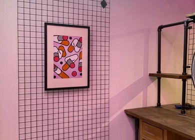 Vibrant wall art in Rythm Barbering, Bristol, England, GB, adds color to the industrial decor.