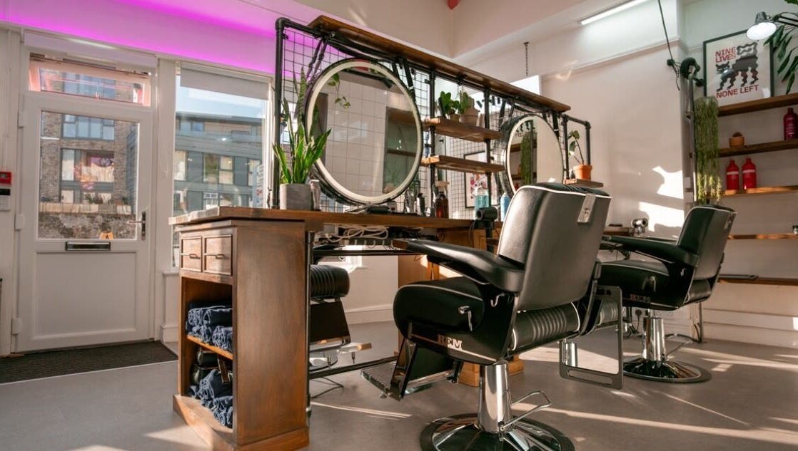 Modern salon interior at Rythm Studio, Bristol, England, GB with stylish chairs and round mirrors.