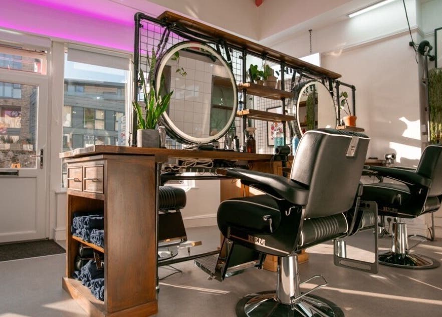 Modern salon interior at Rythm Studio, Bristol, England, GB with stylish chairs and round mirrors.