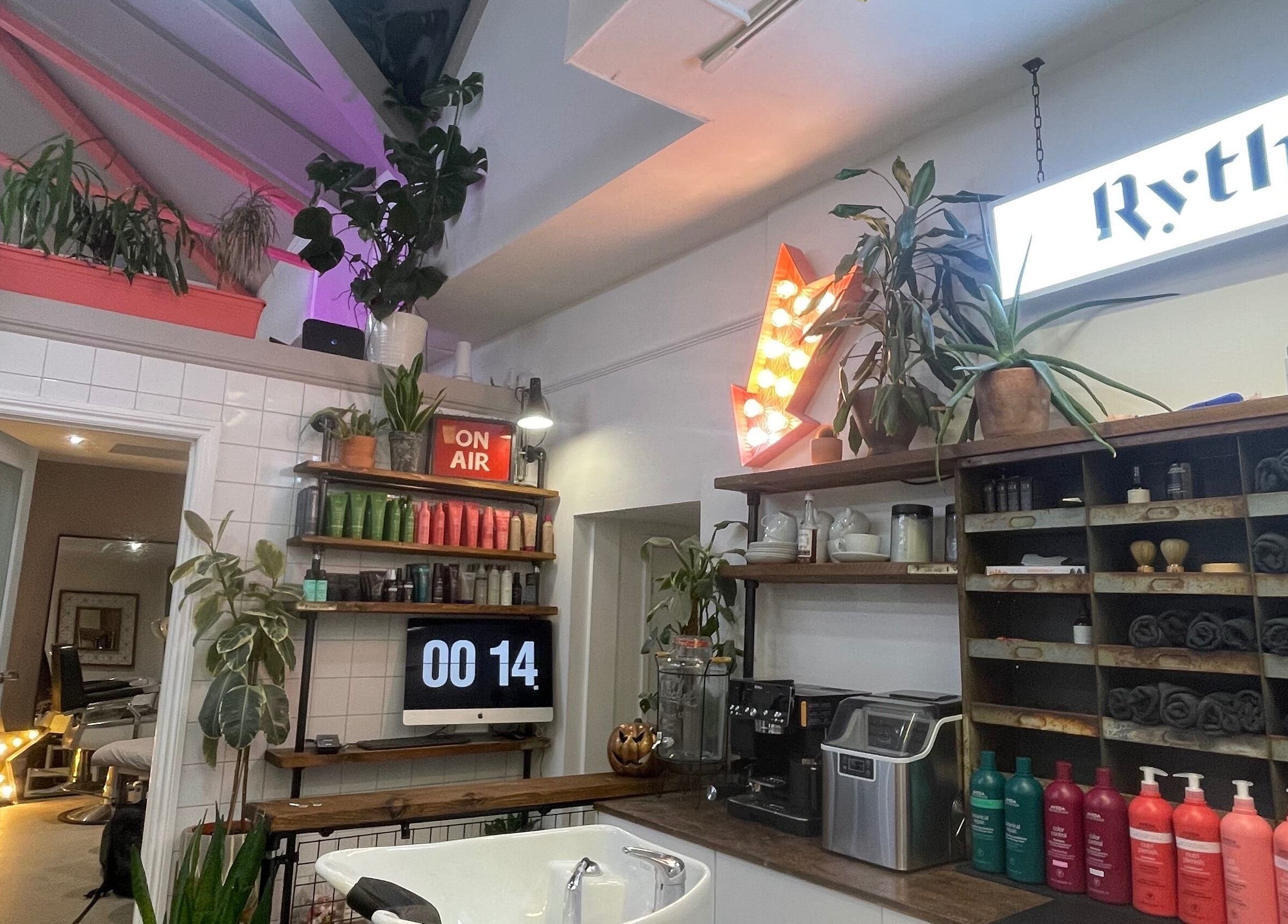 Modern interior of Rythm Studio, Bristol, England, GB featuring vibrant decor and beauty products on display.