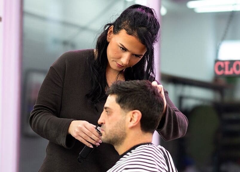 Stylist at Rythm Studio in Bristol, England, GB, precisely cutting a client's hair with attention to detail.
