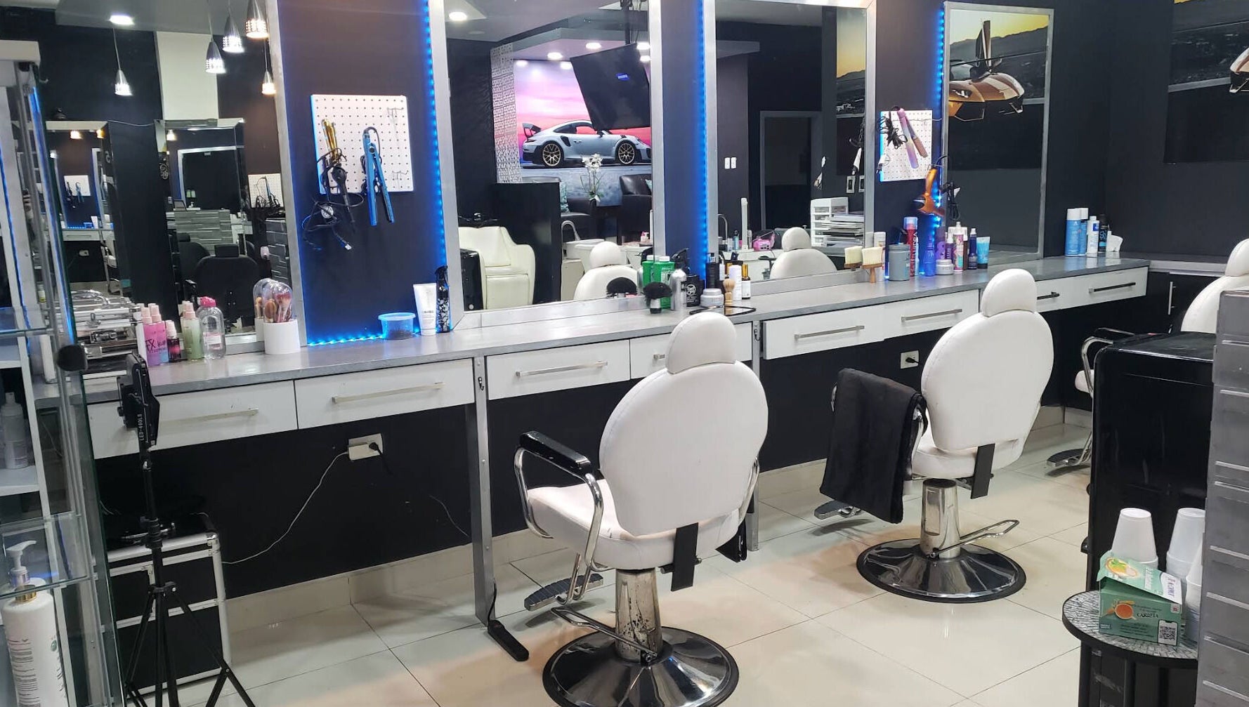 Interior moderno de Chop Shop Salon de Belleza en Tijuana, Baja California, MX, con sillas y productos de belleza.