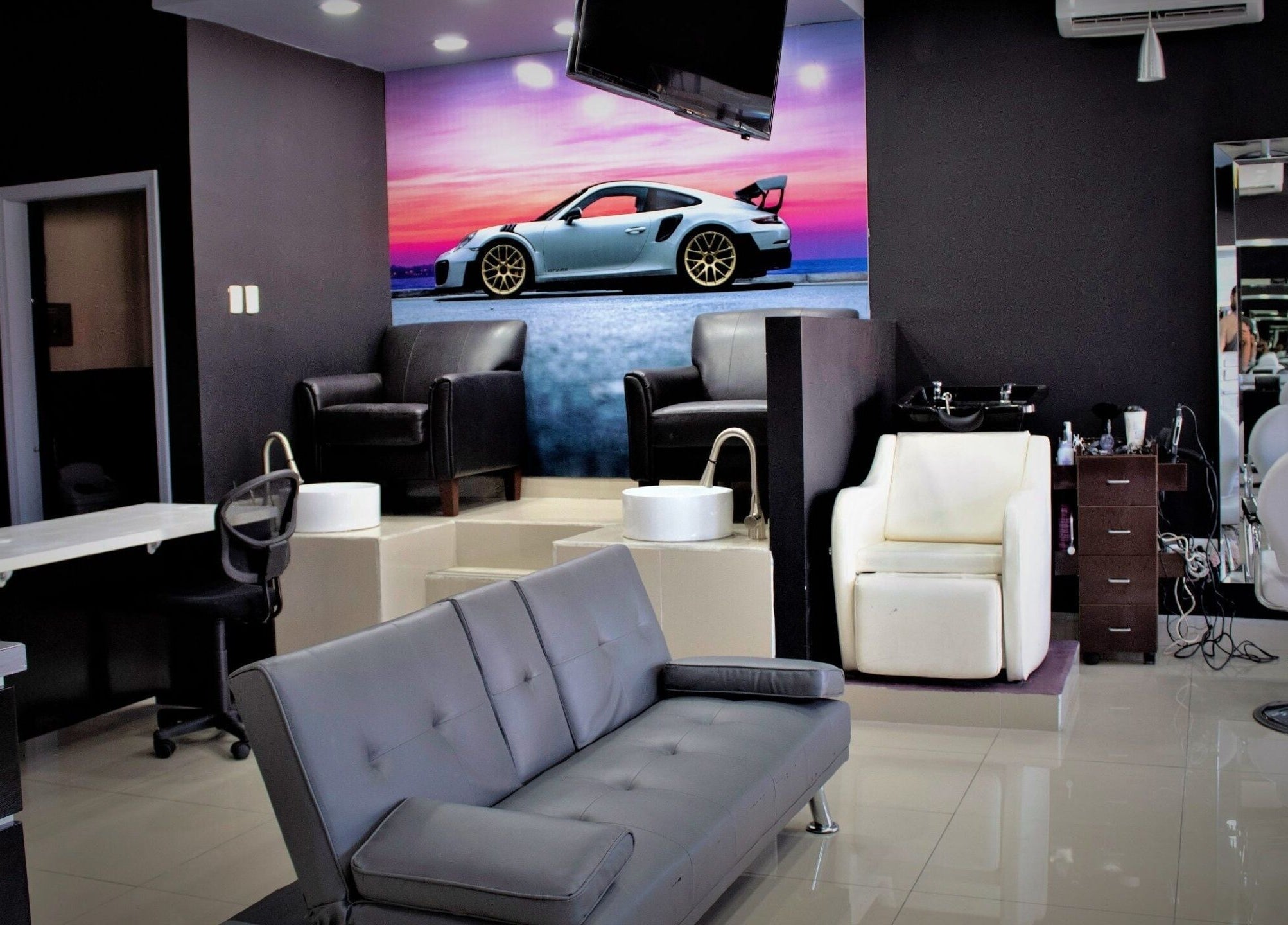 Interior moderno de Chop Shop Salon de Belleza, Tijuana, Baja California, MX con sofás elegantes y sillas estilizadas.