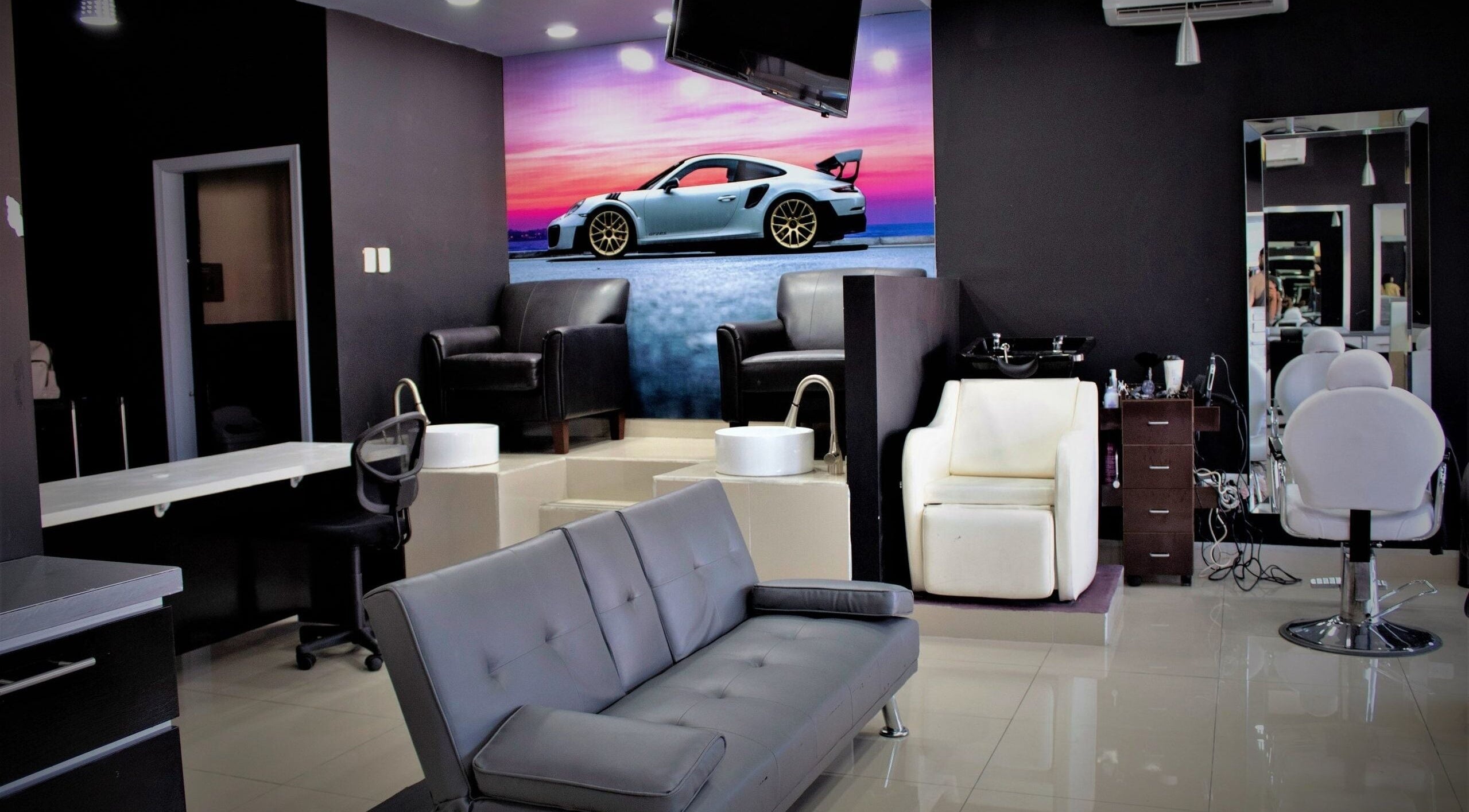 Interior moderno de Chop Shop Salon de Belleza, Tijuana, Baja California, MX con sofás elegantes y sillas estilizadas.