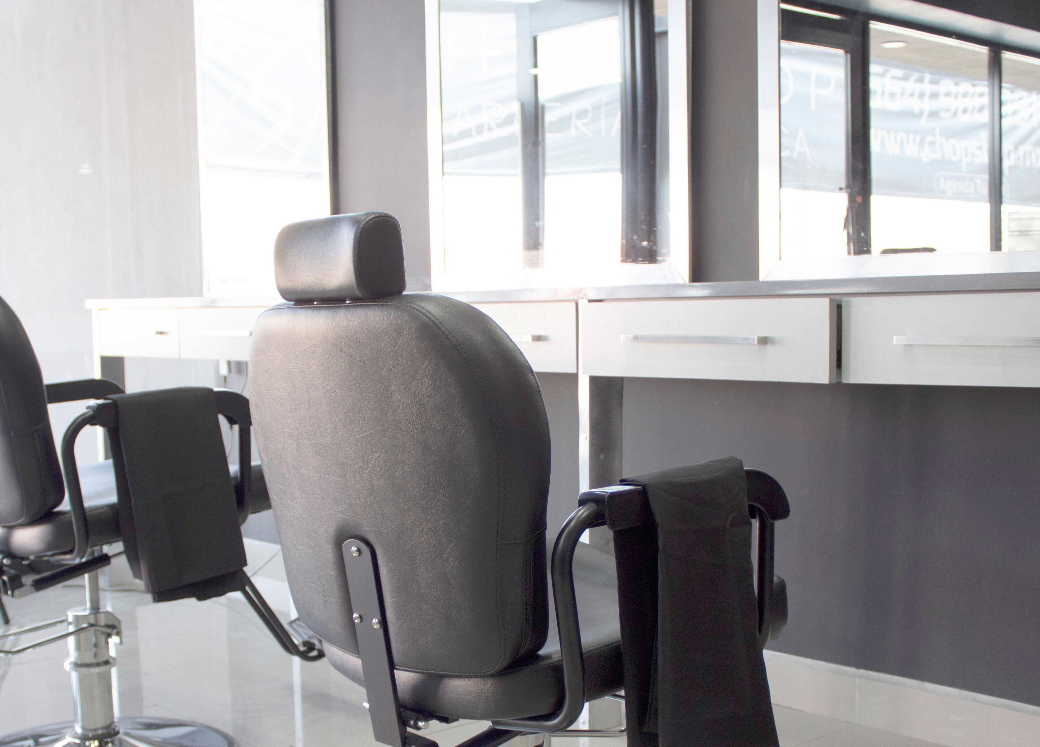 Moderno interior del Chop Shop Salon de Belleza en Tijuana, Baja California, MX, mostrando elegantes sillas.