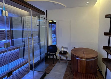 Luxury sauna room at Recovery Space, Dubai, Dubai, AE, featuring wooden decor and calming blue lights.