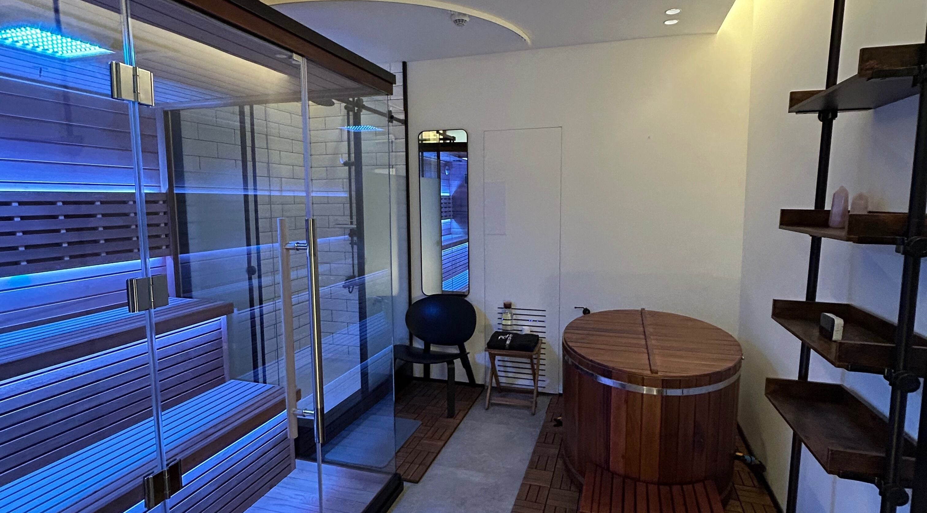 Luxury sauna room at Recovery Space, Dubai, Dubai, AE, featuring wooden decor and calming blue lights.