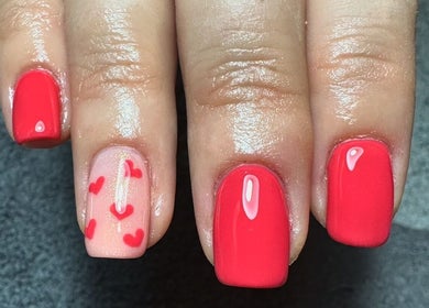 Red polished nails with heart designs at Sage beauty & aesthetics, Wigan, England, GB.